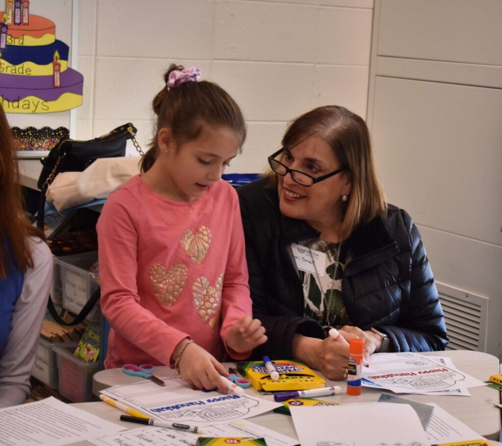 Grandparent and grandchild working together on a school project at Hillel Torah, highlighting family involvement and connection.